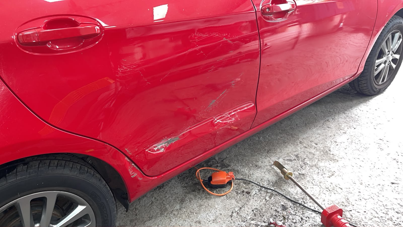Red car with door and side panel damage