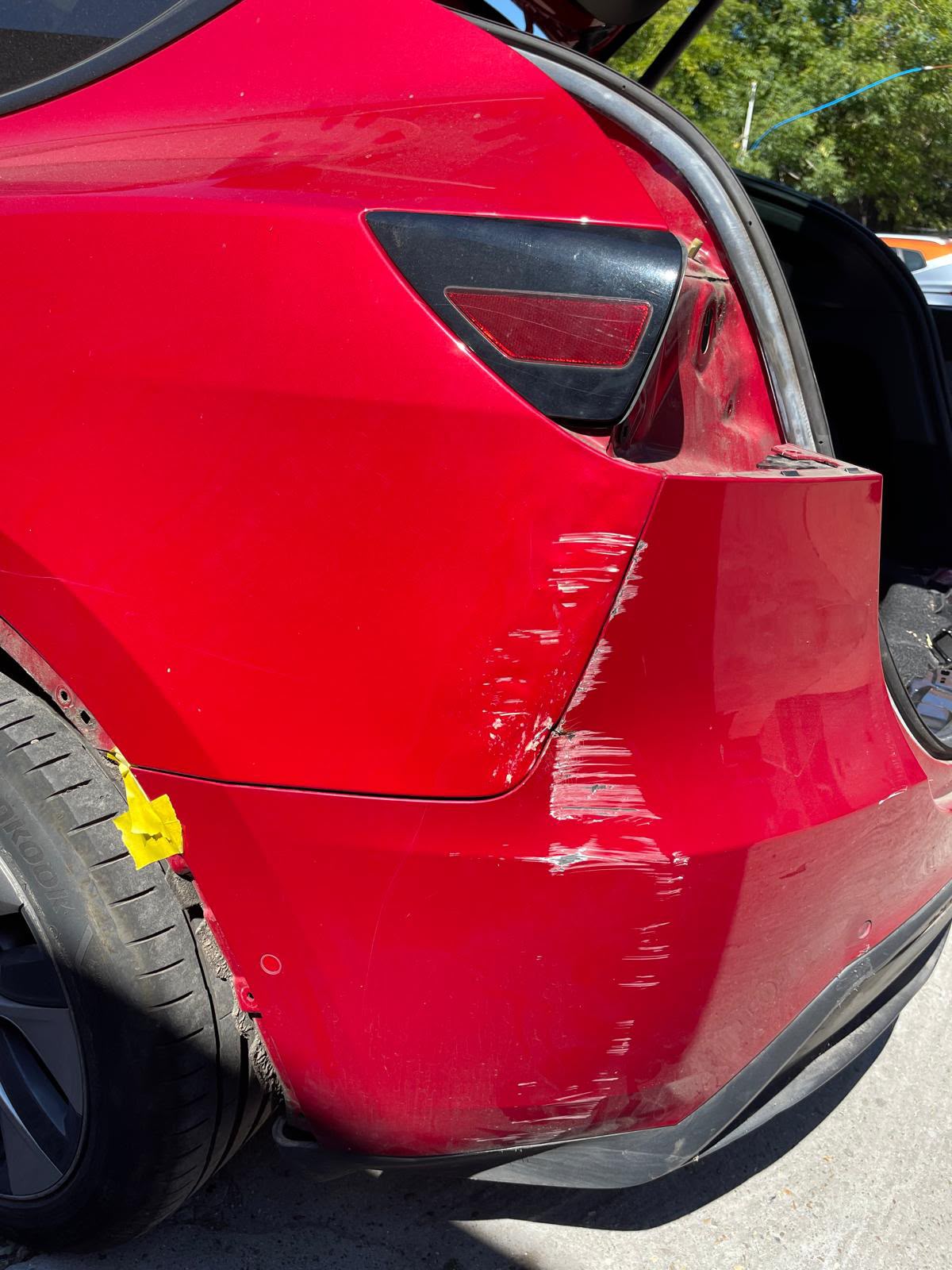 Red car with rear bumper and quarter panel scuffs